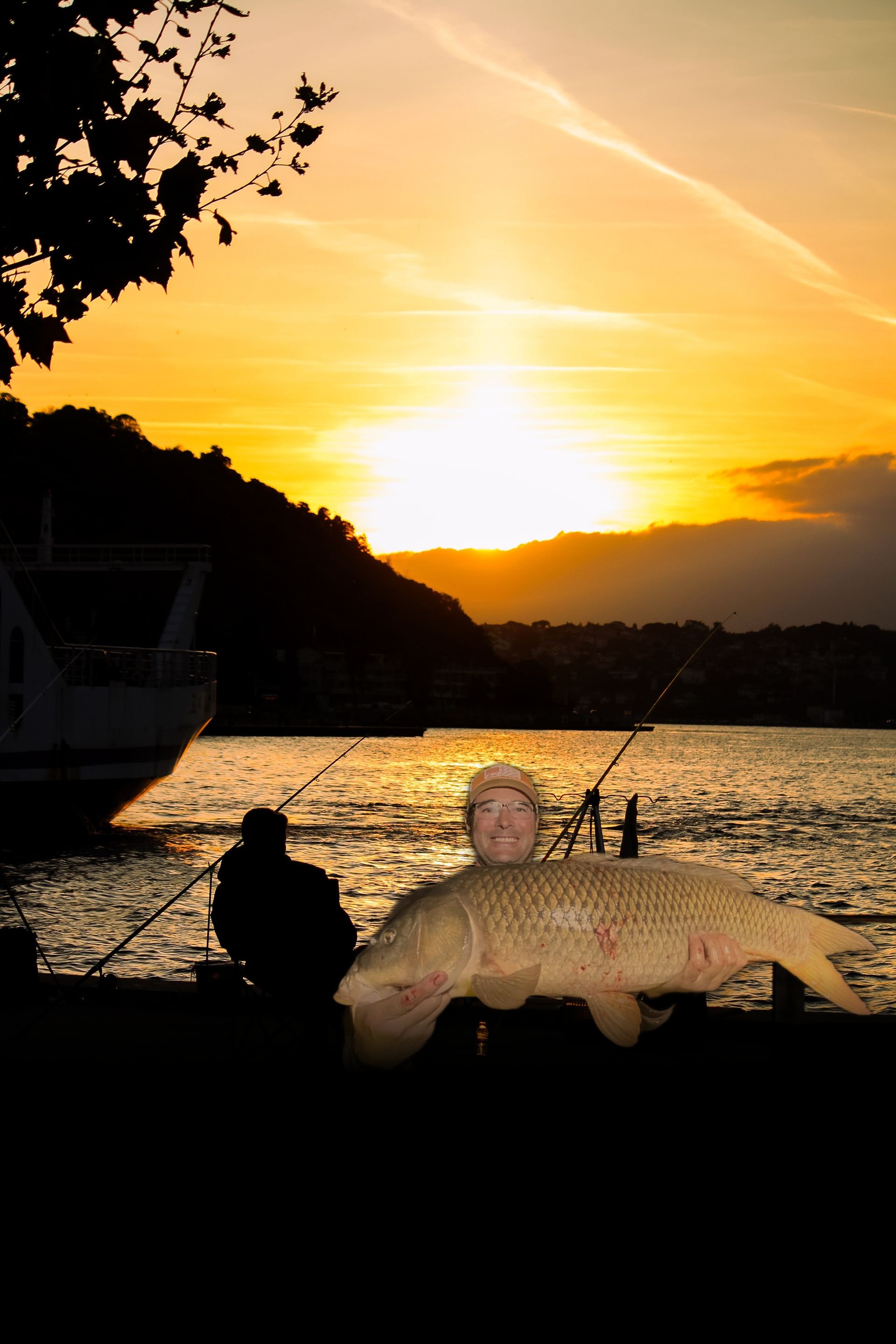 Angler holding a trophy carp against a golden sunset backdrop